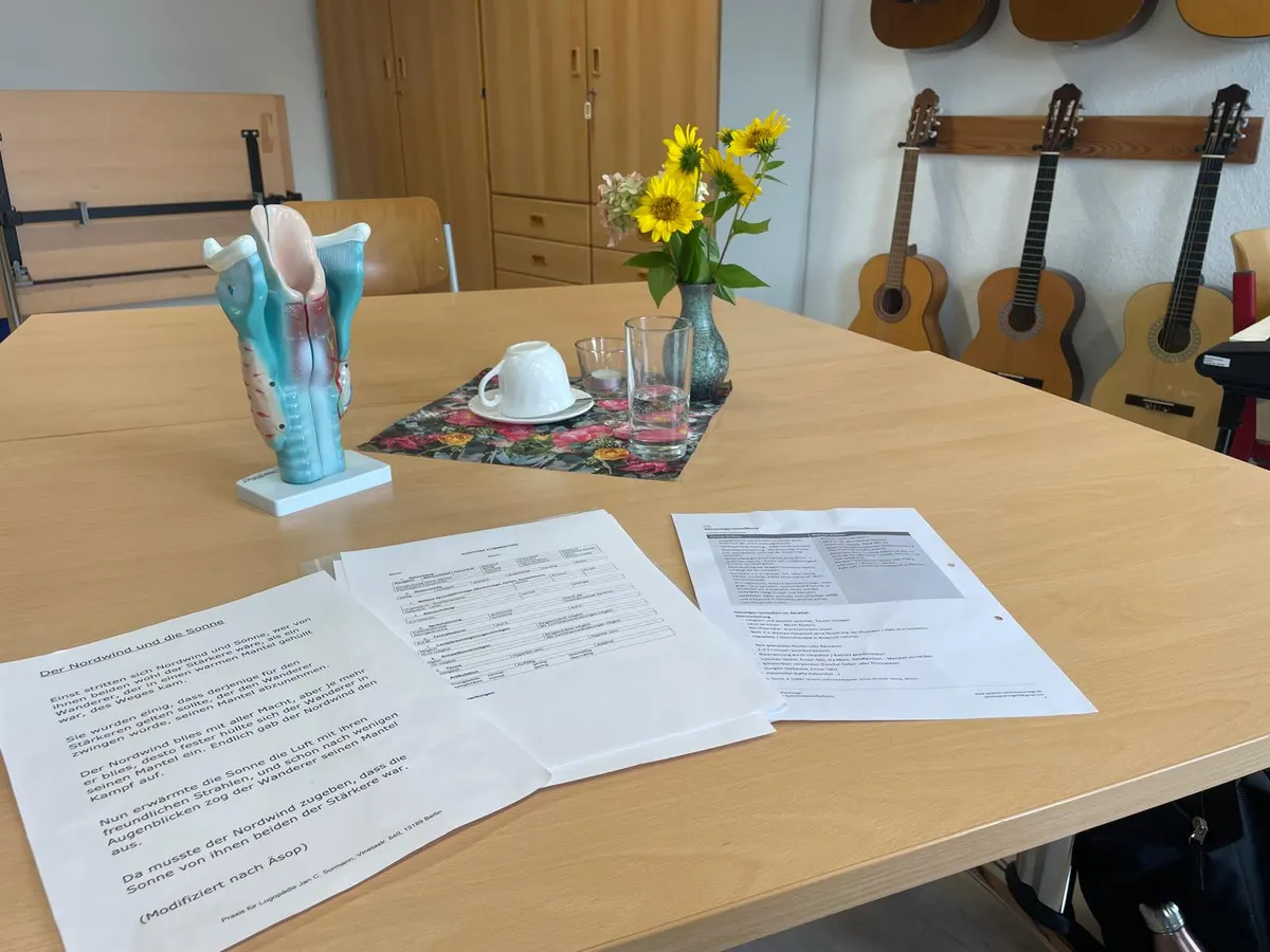 Einblick in Paulines Stimmarbeit: Kehlkopfmodell links auf dem Tisch, daneben Materialien zum Sprechtraining